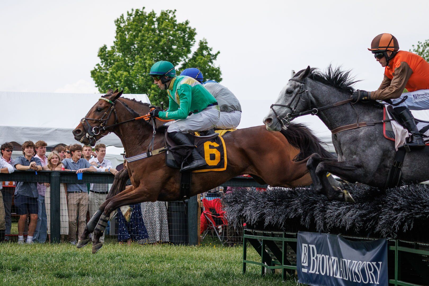 Riders on horses jumping during a competition at Great Meadow