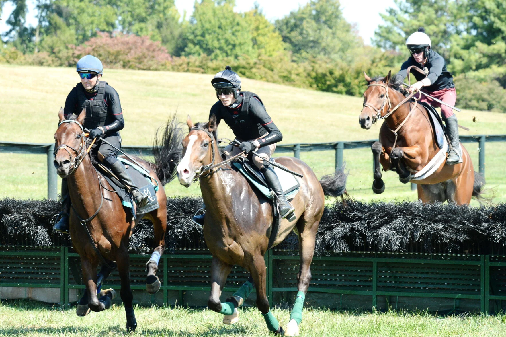 Riders on horses jumping during a competition at Great Meadow